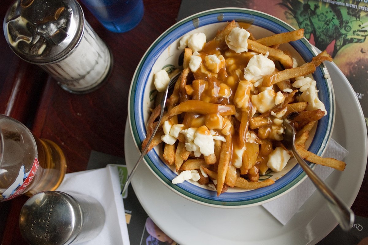 chow-down-on-poutine-a-dish-of-crisp-french-fries-with-brown-gravy-and-cheese-curds-in-montreal-locals-recommend-the-poutine-from-la-banquise